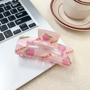 Pinza per capelli in acrilico rosa con stampa pesca dolce su sfondo per laptop