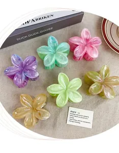Lot de six pinces à cheveux en forme de fleur aux tons pastel sur fond de lin épuré