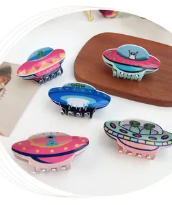 Vue détaillée de pinces à cheveux OVNI en acrylique aux couleurs vives et formes d'alien