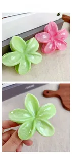 Détail de la pince à cheveux fleur de frangipanier avec texture marbrée crème