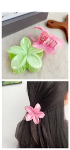 Gros plan de pinces à cheveux en forme de fleur rose et verte avec détail de ressort