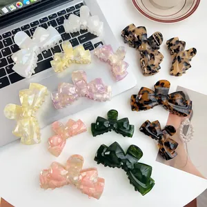 Detailed top view of assorted acetate bow hair claws in marble and tortoiseshell patterns