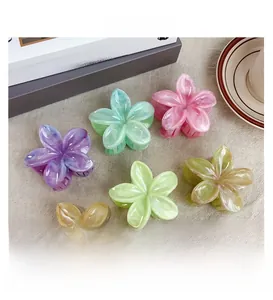 Détail de pinces à cheveux fleur en couleurs crème avec texture résine marbrée et dents