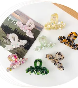 Collection of flower-shaped acetate hair claws in various colors with rhinestone centers