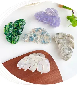 Detailed close-up of leaf-shaped acetate hair claws in assorted marble and shell patterns