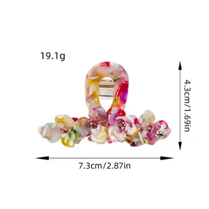 Three-petal floral acetate hair claw with pink rhinestones and colorful marbled texture