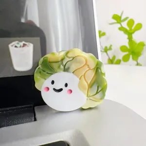 Detail of cute acrylic cabbage hair claw with a gradient green leaf and smiling face
