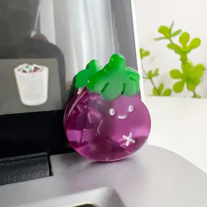 Close-up of cute purple eggplant hair claw clip with smiley face and green leaf detail