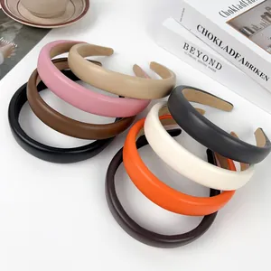 Collection of thick padded sponge headbands in various colors on a minimalist desk