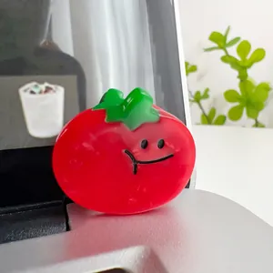Close-up of cute red tomato acetate hair claw clip with a smiley face and green leaf detail