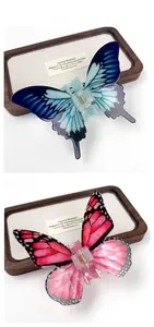 Close-up of gradient blue and pink acrylic butterfly hair clips with gold metal springs