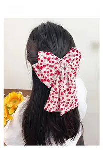 Barrette à nœud floral avec perles blanches et motif fleurs rouges sur les cheveux