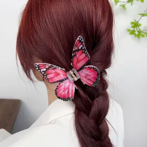Elegant acrylic butterfly hair claw clip with pink and black wings on hair