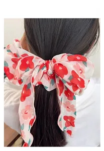 Detail eines großen roten Blumen-Haargummis aus leichtem Chiffon mit Blumenmuster