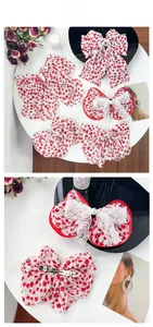 Détail d'un chouchou à fleurs rouges avec bords en dentelle et perles élégantes