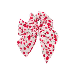 Chouchou à fleurs rouges avec nœud papillon sur tissu en coton blanc