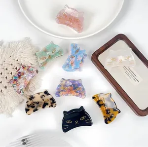 Various cat-shaped acetate hair claws in nine colors arranged on a white background
