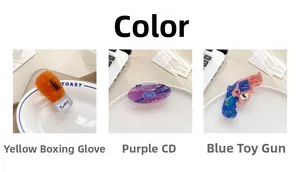 Detailed view of novelty boxing glove, CD record, and blue pistol acetate hair claws
