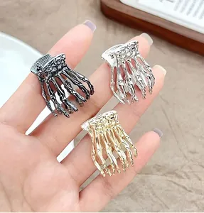 Detailed view of skeleton hand hair clips in gold, silver, and black metallic finishes