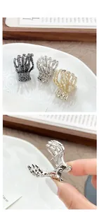 Detailed view of skeleton hand hair claws in gold, silver, and black metallic finishes