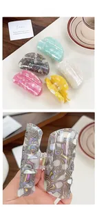 Detail of marble pattern PVC hair claws showing spring mechanism and various colors