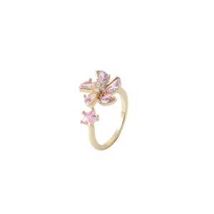 Gold spinning ring featuring pink zircon flower and star stones in a minimalist style