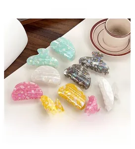 Close-up of colorful spotted PVC hair claws with pearl shell and marble texture
