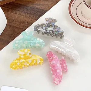 Five pieces of large patterned hair claw clips in colorful marble and geometric designs