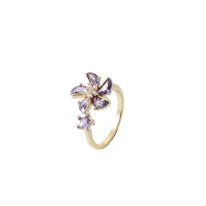 Golden flower ring featuring purple zircon petals and a sparkling star ornament