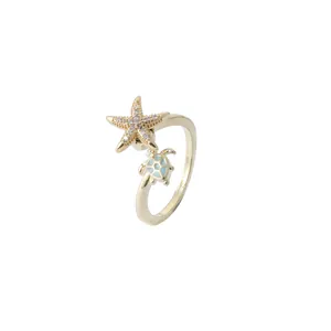 Golden starfish and blue sea turtle ring with sparkling micro-pave crystals