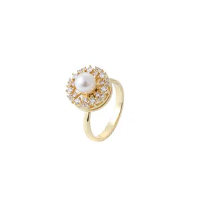 Elegant gold ring featuring a central white pearl surrounded by sparkling crystal halo