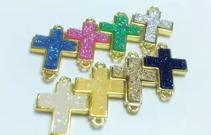 Detailansicht bunter Kreuzanhänger mit glitzernden Kristallen für DIY-Schmuckherstellung
