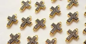 Nahaufnahme der goldenen Kreuzverbinder mit glänzendem Druzy-Kristall und zwei Ösen
