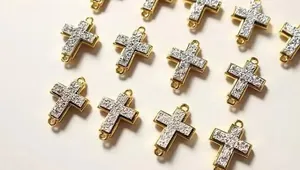 Detailansicht goldbeschichteter Kreuz-Verbinder mit weißen Kristallen für Schmuckdesign