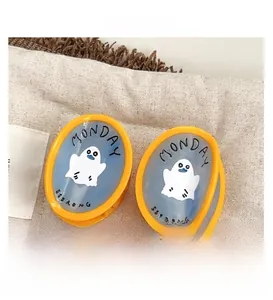 Détail de pinces à cheveux jaunes avec design de fantôme bleu et motif Monday