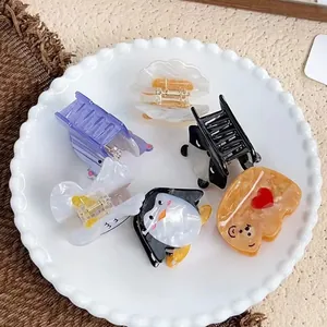 Set di mollette per capelli in acetato con orsetti e pinguini su un vassoio di ceramica