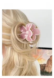 Detail of pink floral plumeria hair claw clip with glossy resin petals on blonde hair