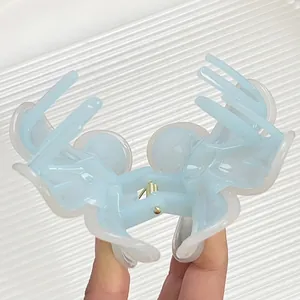 Blue and translucent white frangipani hair claw clip with golden metal spring