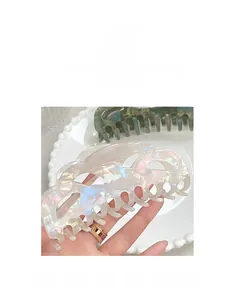 Macro detail of an iridescent pearl white claw clip with elegant hollow wavy design