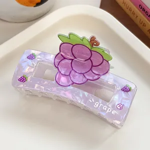 Detail of square hair claw clip with purple marble texture and 3D grape motif design