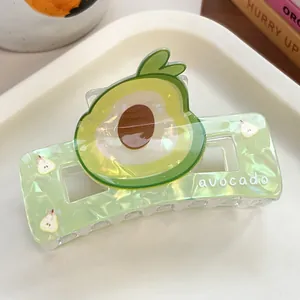 Macro shot of translucent green avocado hair claw clip with avocado print and text