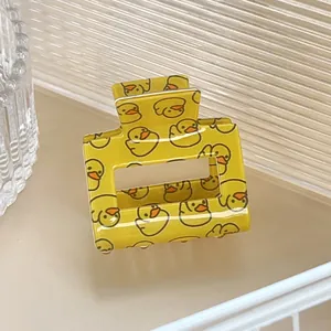 Détail d'une pince à cheveux rectangulaire jaune avec motif de canard mignon