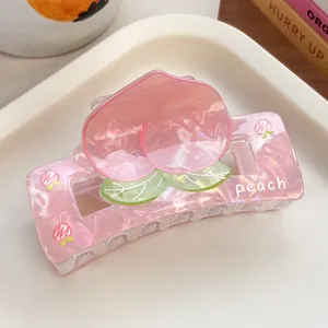Close-up of pink peach hair claw clip with marble texture and peach print detail