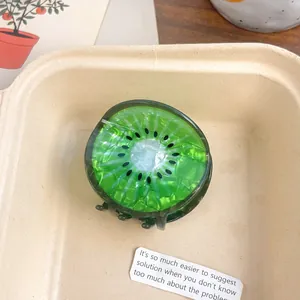 Gros plan d'une pince à cheveux motif kiwi en acrylique vert avec texture marbrée