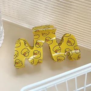 Gros plan d'une pince à cheveux jaune avec motif de canard et bords ondulés élégants