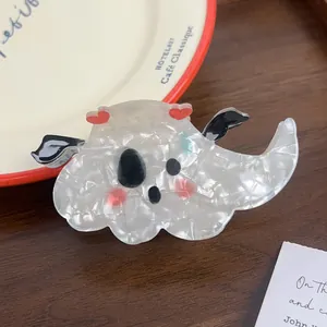Detailed shot of a marble-textured ghost hair claw clip with red hearts on a vintage plate