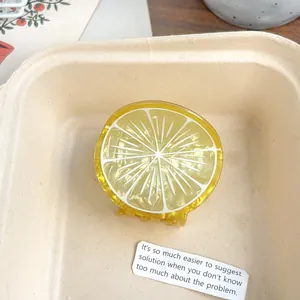 Gros plan sur une pince à cheveux jaune en forme de citron en acétate de haute qualité