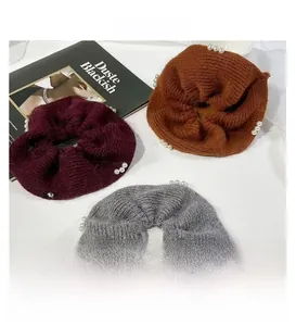 Detaillierte Textur von Strick-Scrunchies in Weinrot, Braun und Grau mit Perlenbesatz