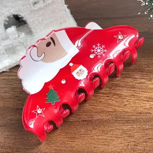 Détail d'une pince à cheveux Père Noël rouge avec strass et motifs festifs