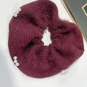 Eleganter weinroter Strick-Scrunchie mit weißen Perlen-Akzenten auf weißem Grund